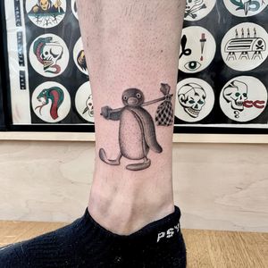 Get inked with a cute and detailed penguin design by tattoo artist Martin Rosenberg, known for his black and gray style.