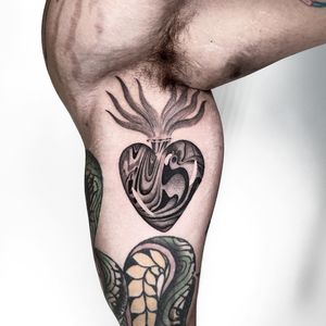 Experience the depths of emotion with this black and gray fine line upper arm tattoo by Martin Rosenberg. A unique twist on the classic sacred heart motif.
