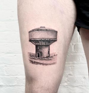 Experience the intricate details of a micro_realism building tattoo by Martin Rosenberg on your upper leg.