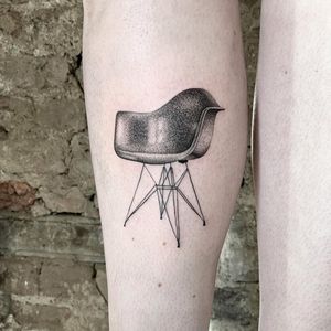 Discover the intricate beauty of Martin Rosenberg's dotwork and fine line micro realism tattoo featuring the iconic Eames chair motif on your lower leg.