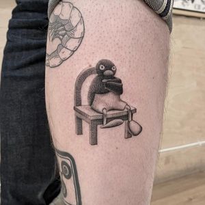 Adorable cartoon penguin tattoo done in black and gray by artist Martin Rosenberg. Perfect for penguin lovers!