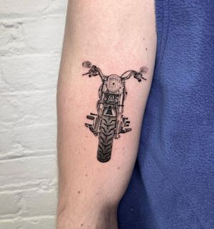 Get revved up with this stunning motorcycle tattoo by artist Martin Rosenberg. Take your love for bikes to the next level with this realistic design.