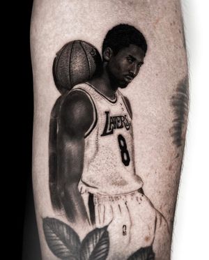 Capture the essence of the legendary Kobe Bryant with a black and gray realism tattoo on your upper arm by Jay Soze.