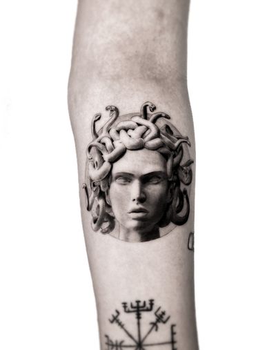 Get mesmerized by this black and gray tattoo featuring a fierce medusa and a menacing snake, expertly done by Jay Soze.