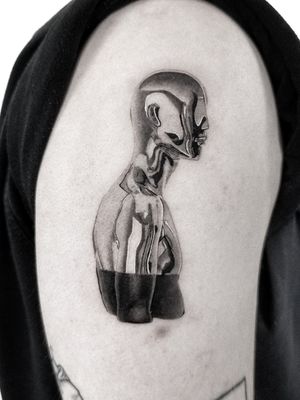 Get a stunning black and gray upper arm tattoo of a statue, expertly done by renowned artist Jay Soze.