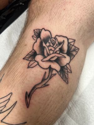 Beautiful fine line flower tattoo on lower leg by Kayleigh Cole.