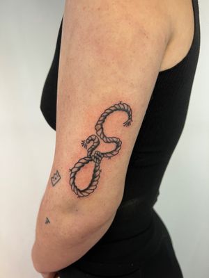 Get a stunning black and gray rope design on your upper arm by the talented artist Kayleigh Cole.