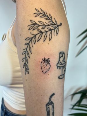 Elegantly detailed fine line strawberry tattoo on upper arm, by talented artist Kayleigh Cole.