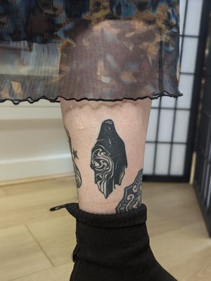Dive into the haunting world of blackwork with this intricate ghost pattern tattoo by George Antony on lower leg.