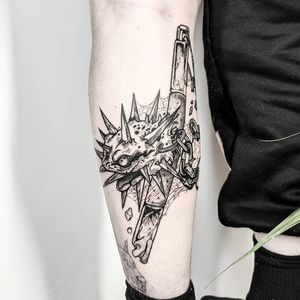 A unique black and gray lower leg tattoo featuring a new school design of a dragon and fish linked together by a chain, by George Antony.