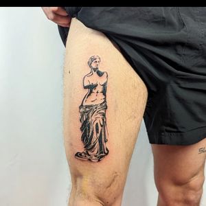 Experience the timeless beauty of George Antony's blackwork statue tattoo design, showcasing intricate details on your upper leg.