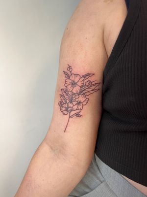 Elegant fine line flower design by Kayleigh Cole, perfect for upper arm placement.