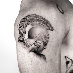 Detailed micro realism tattoo of a portrait sculpture on the upper arm, expertly done by artist Jay Soze.