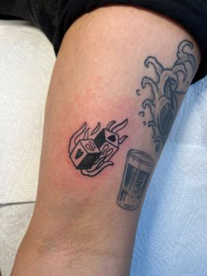 Get lucky with this bold black and gray dice tattoo on your upper arm, expertly done by Kayleigh Cole.