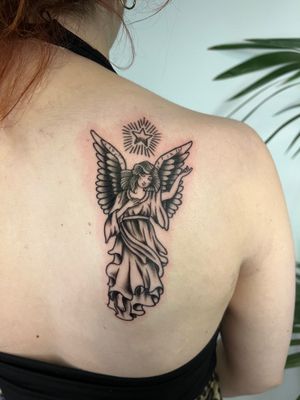 Get a stunning upper back tattoo of an angel in black & gray by the talented Kayleigh Cole. Transport yourself to another realm.