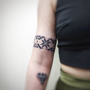 Elegant blackwork and ornamental dotwork pattern tattoo by Chun Lee on the upper arm.