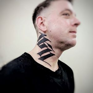 Explore the artistry of blackwork with this stunning patterned lettering tattoo on the neck by renowned artist Chun Lee.