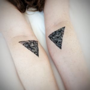 Fine line pattern of triangles by Chun Lee on forearm, creating a modern and stylish design.