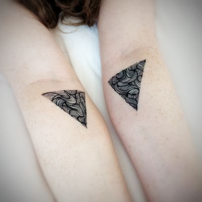 Fine line pattern of triangles by Chun Lee on forearm, creating a modern and stylish design.