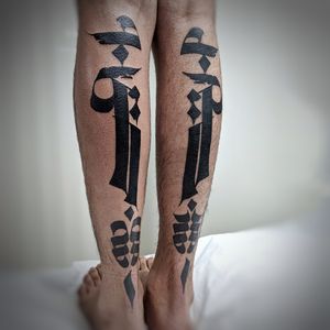 Chun Lee creates a bold blackwork design with intricate patterns and a meaningful quote on the lower leg.