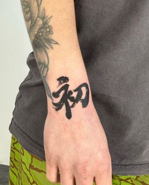 Get a bold and stylish kanji lettering tattoo by Hansol Jung showcasing intricate blackwork design on your forearm.