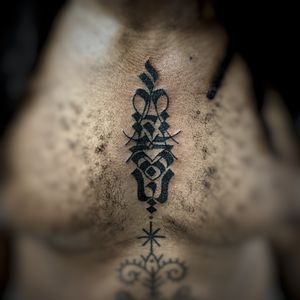 Bold tribal pattern chest tattoo by Chun Lee, showcasing intricate blackwork design.