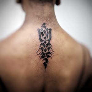 Elegant ornamental design by Chun Lee, adorning the upper back with a mesmerizing pattern and symbolic sign in black ink.