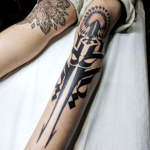 Embrace the intricate beauty of blackwork tribal art with this mesmerizing mandala pattern tattoo on your knee by Chun Lee.