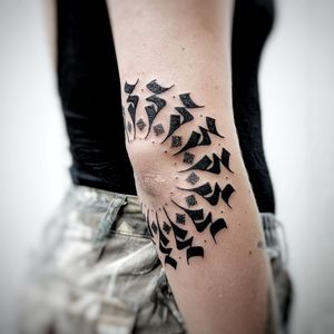 Unique blackwork design by tattoo artist Chun Lee featuring intricate tribal motifs and dotwork patterns on the elbow.