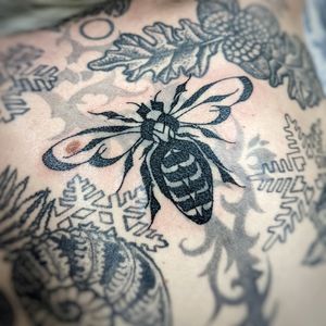 Experience the intricate beauty of this blackwork bee tattoo on your chest, expertly crafted by the talented artist Chun Lee.