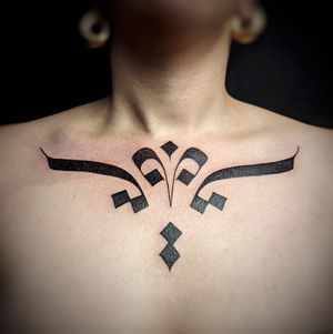 An intricate blackwork tribal pattern chest tattoo by Chun Lee, showcasing bold and striking design.