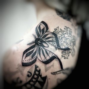Stunning blackwork design by Chun Lee featuring delicate butterfly and moth motifs on upper back.