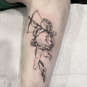 Get inked by Federico Colantoni with this delicate upper arm tattoo featuring a stunning angel and cupid motif. Perfect for those seeking a touch of heavenly beauty.