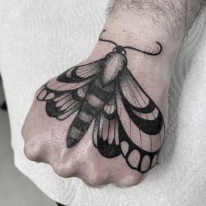 Adorn your hand with a stunning blackwork moth tattoo by Federico Colantoni, perfect for a touch of elegance.