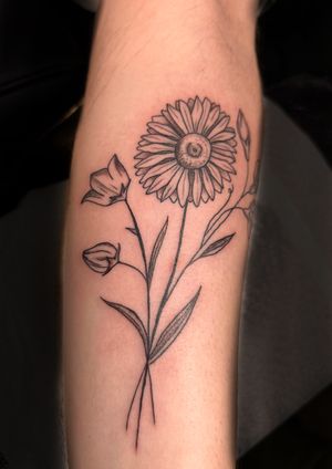 Beautifully detailed sunflower tattoo by Kiky Flore, showcasing intricate floral design in fine line style on lower arm.