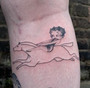 Unique arm tattoo combining a horse and Betty Boop in a delicate fine line style by Fresh Flower.