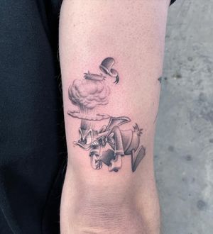 Experience the whimsical charm of a black and gray micro realism duck tattoo on your arm, brought to life by Fresh Flower's expert hand.