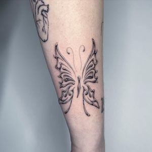 Elegant black and gray butterfly tattoo on forearm, meticulously done by Fresh Flower.