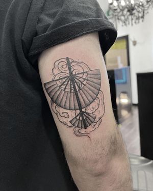 Elegant black and gray fan tattoo on the arm, expertly crafted by the talented artist Federico Colantoni.