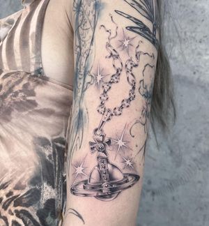 Get a stunning black and gray tattoo of a detailed chain and pendant design by the talented artist Fresh Flower. Perfect for arm placement.