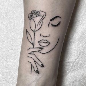 This exquisite fine line tattoo on the forearm features a beautiful design of a flower intertwined with a woman, crafted by the talented Federico Colantoni.