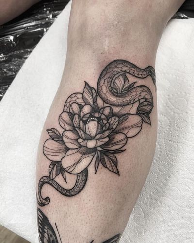 Get a stunning fine line floral tattoo featuring a snake and flower motif on your shin by the talented artist Federico Colantoni.