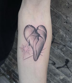 Get a stunning black and gray heart tattoo on your forearm by the talented artist Fresh Flower. This sleek design is perfect for those looking for a timeless and elegant piece of body art.