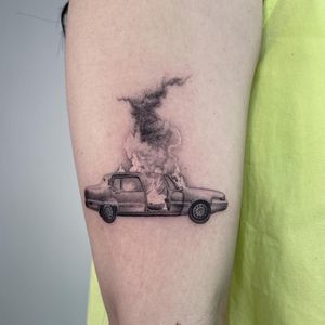 Get ready to turn heads with this detailed black and gray micro-realism tattoo of a car engulfed in flames, expertly done by Fresh Flower on your upper arm.