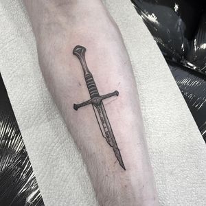 Impressive blackwork sword tattoo by artist Federico Colantoni, perfect for a bold statement on your forearm.