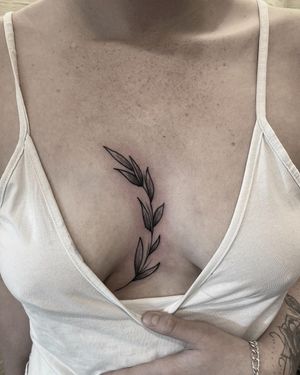 Experience nature with this intricate black and gray leaf tattoo on your chest by Federico Colantoni.