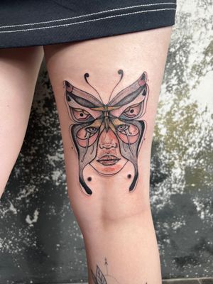 Elegant neo-traditional design by Kiky Flore featuring a butterfly, moth, and face motif on upper leg.