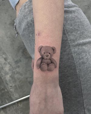 Capture the adorable essence of a teddy bear with this black and gray micro realism tattoo by Fresh Flower on your forearm.