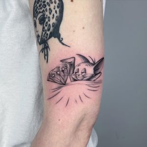 Capture the whimsical charm of a cartoon rat holding a sparkling diamond in this detailed black and gray micro realism tattoo by Fresh Flower. Perfect for arm placement.