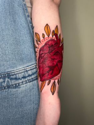 Get inked with this beautiful forearm tattoo featuring a heart and leaf motif by the talented artist Kiky Flore.